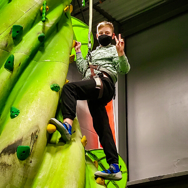 Student poses during a wall climbing field trip at NorthStar Academy Online School